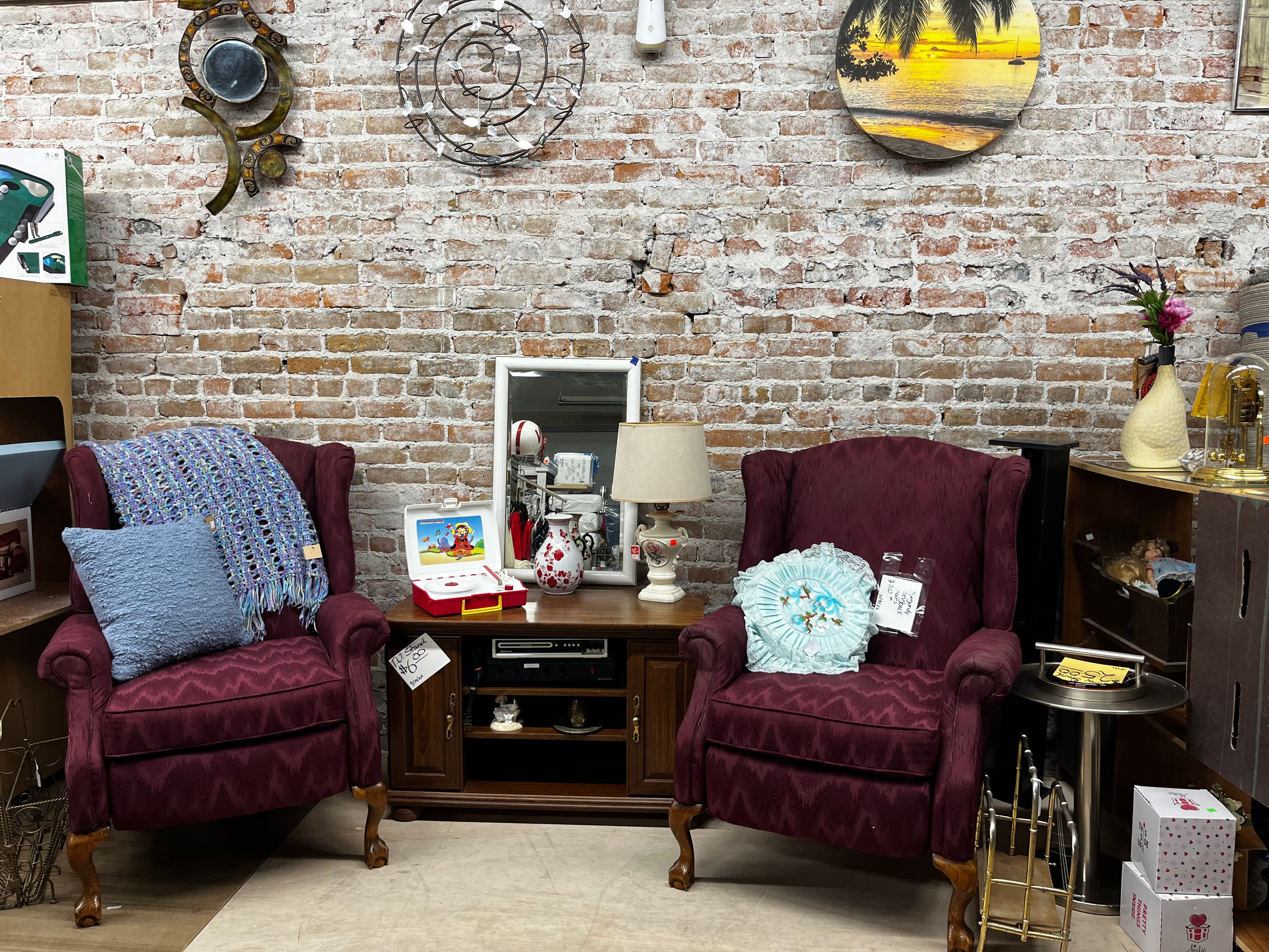 First floor wingback chairs and home furnishings against brick wall